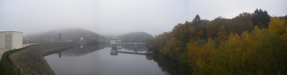 Reservoir behind a dam, surrounded by forest