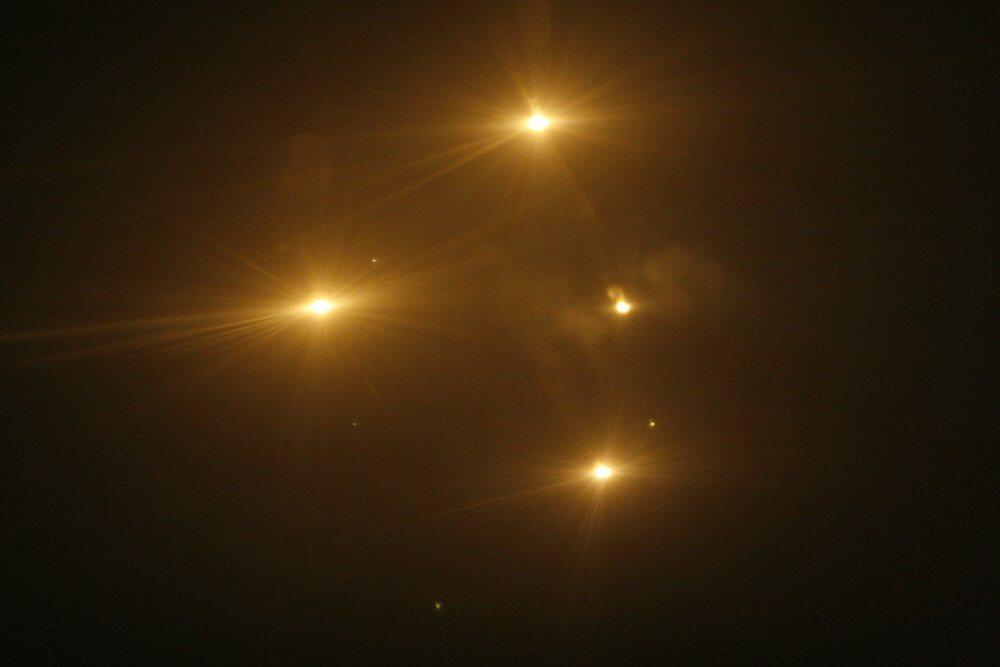 Row of bright orange lights in the night sky