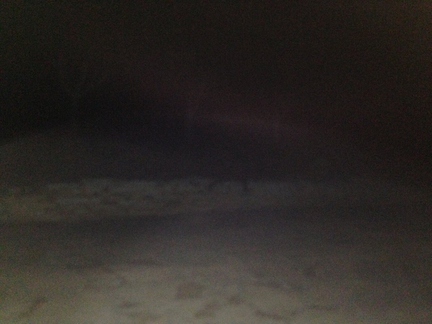 Night photo that is almost entirely dark; the flash lit only the stone ground near the camera